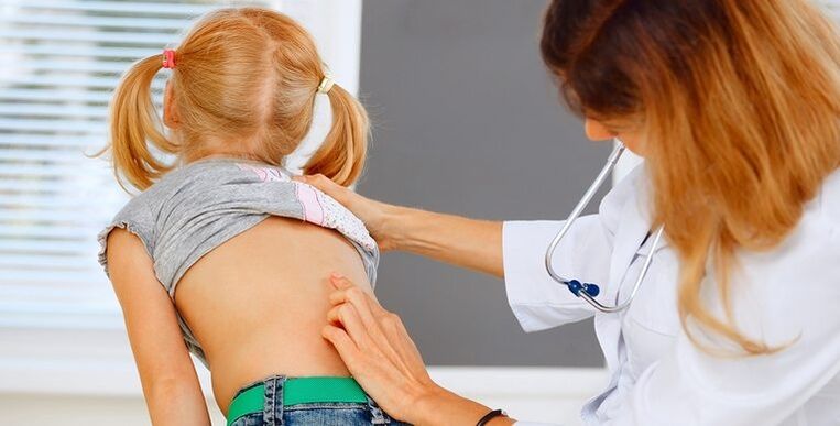 Médico examinando as costas dun neno para detectar dor lumbar
